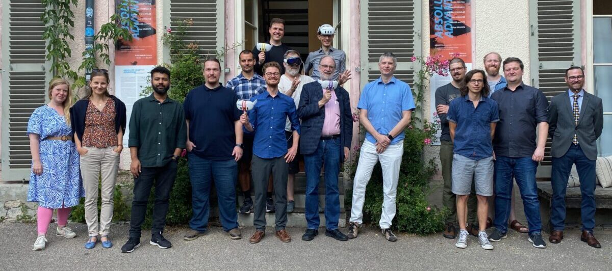A group of people from the Multiparties project is standing in front of a building